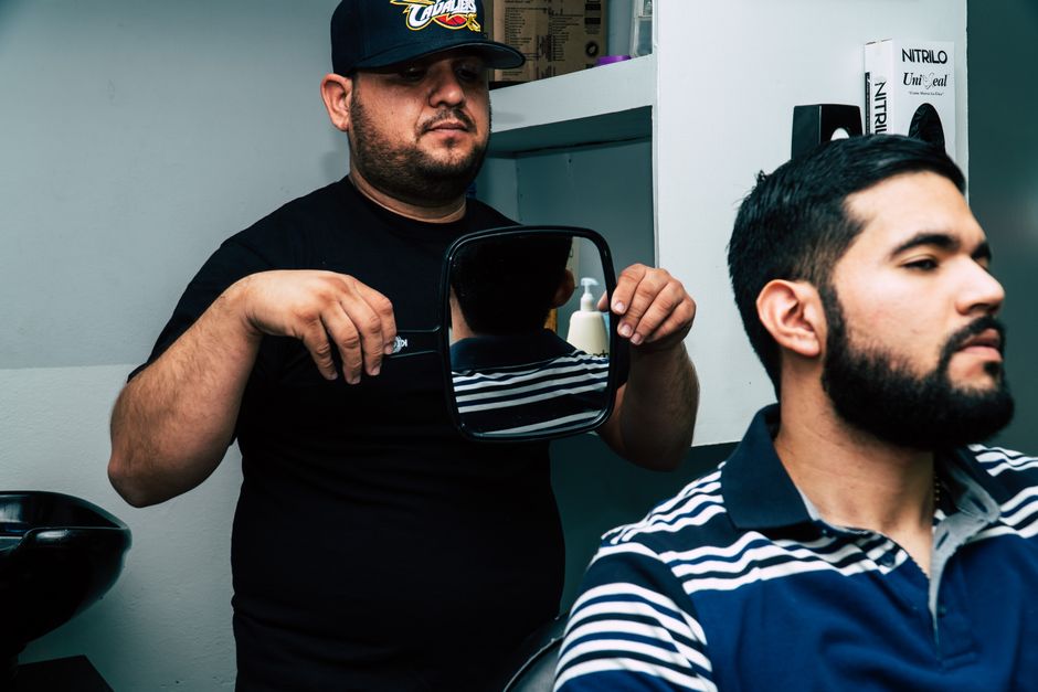 Barber consulting a client on style